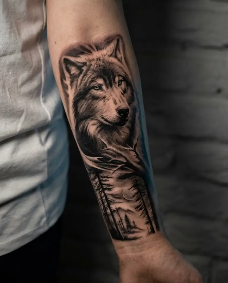 Black and grey realism wolf forest tattoo on the forearm.