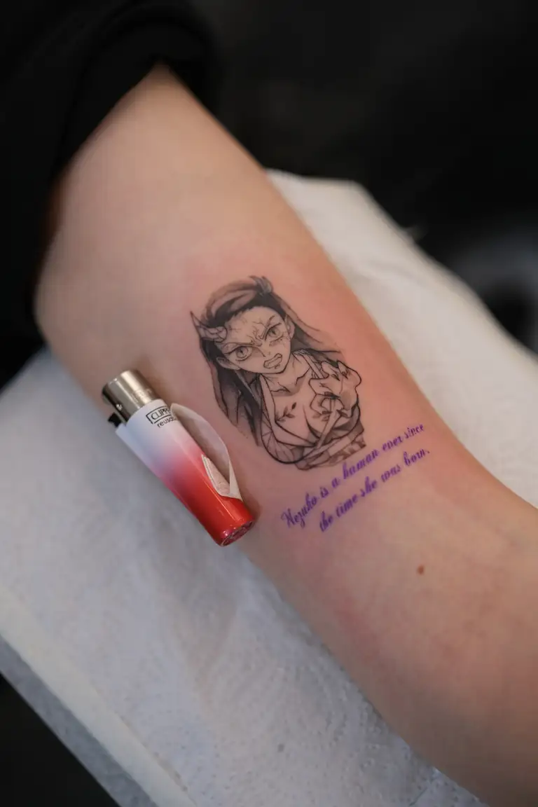 Anime and manga inspired fine-line tattoo with delicate script lettering.